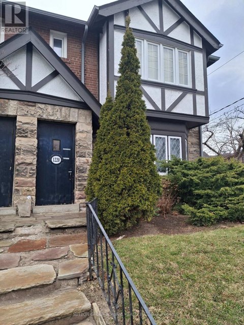 A house with a black door and a stone wall.
