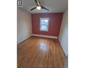 A room with a ceiling fan and wooden flooring.