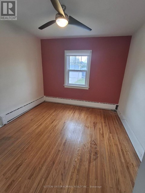 A room with a ceiling fan and wooden flooring.