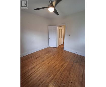 A room with a ceiling fan and wooden flooring.