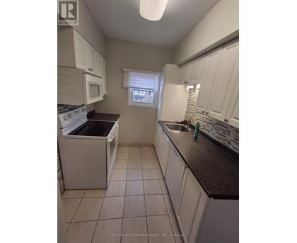 A kitchen with white cabinets and a black counter top.