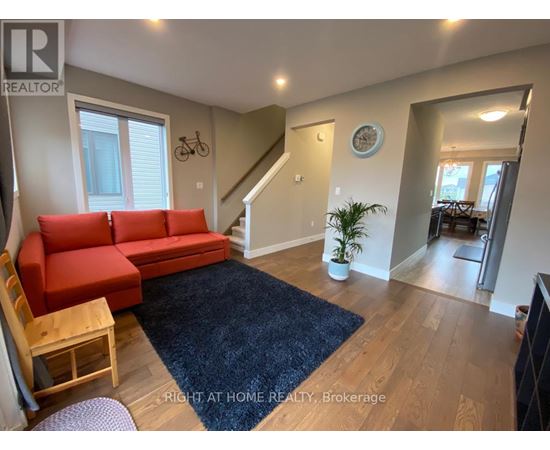 A living room with a red couch and a blue rug.
