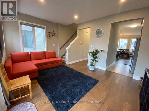 A living room with a red couch and a blue rug.