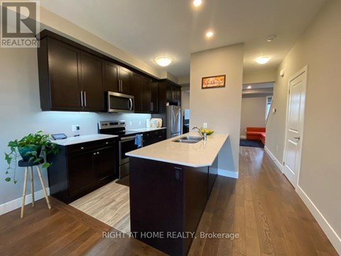 A kitchen with dark brown cabinets and a white countertop.