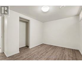 A room with a door and a window, with a wooden floor.