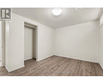 A room with a door and a window, with a wooden floor.
