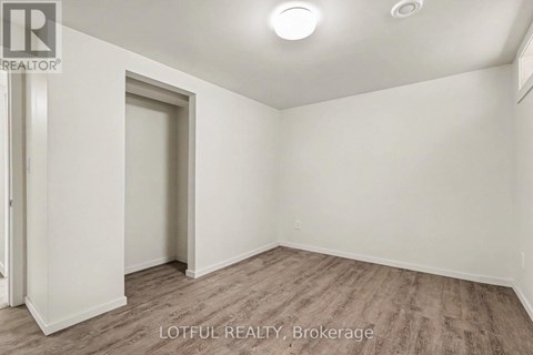 A room with a door and a window, with a wooden floor.