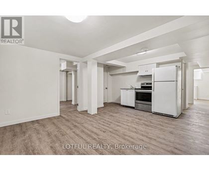 A spacious kitchen with white appliances and wooden flooring.