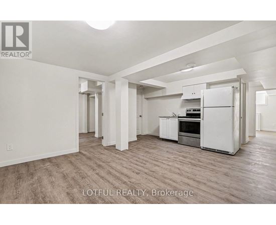 A spacious kitchen with white appliances and wooden flooring.
