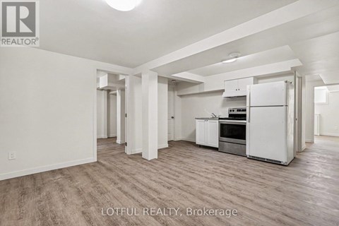 A spacious kitchen with white appliances and wooden flooring.