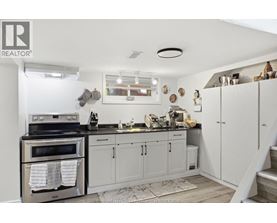A kitchen with white cabinets and a black stove top.