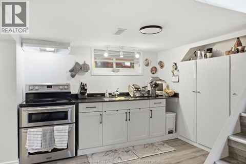 A kitchen with white cabinets and a black stove top.