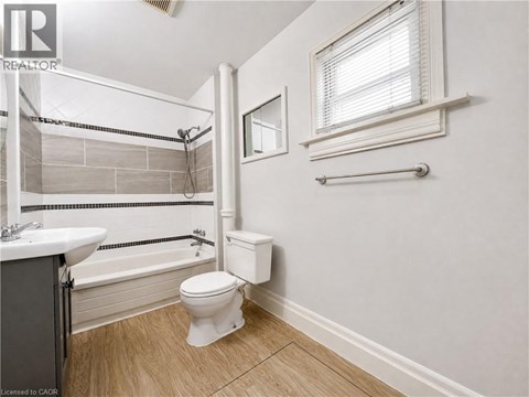 A bathroom with a toilet, sink, and bathtub.