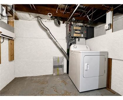 A room with a white wall and a furnace.