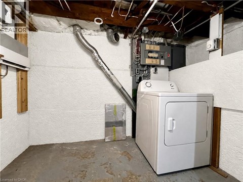 A room with a white wall and a furnace.