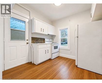 A kitchen with white cabinets and a wooden floor.