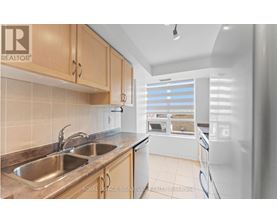 A kitchen with a sink and a refrigerator.