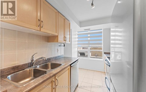 A kitchen with a sink and a refrigerator.