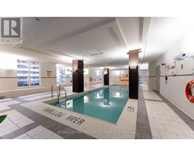 A swimming pool in a room with a sign that says "SHALLOW WATER".