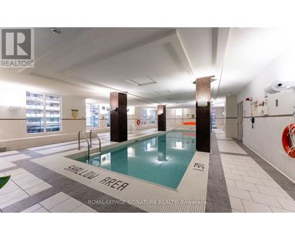 A swimming pool in a room with a sign that says "SHALLOW WATER".