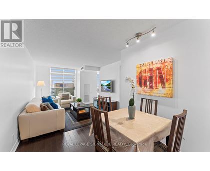 A living room with a couch, a coffee table, a dining table and chairs.