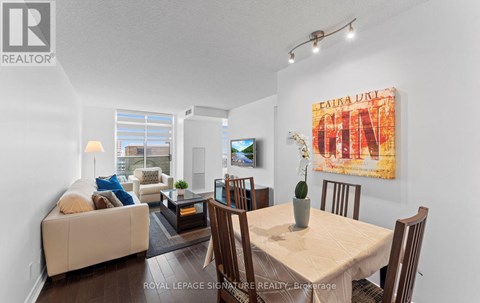 A living room with a couch, a coffee table, a dining table and chairs.