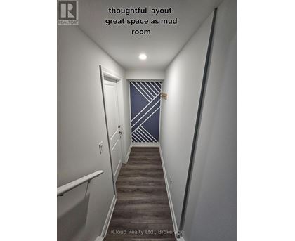 A hallway with a wooden floor and a striped wallpaper on the wall.