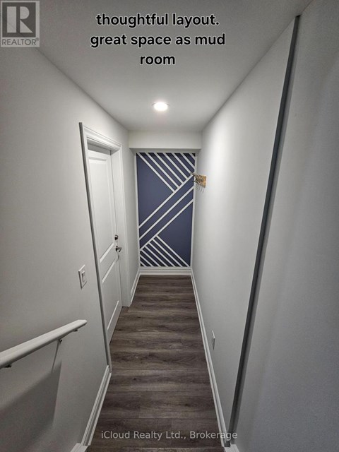 A hallway with a wooden floor and a striped wallpaper on the wall.