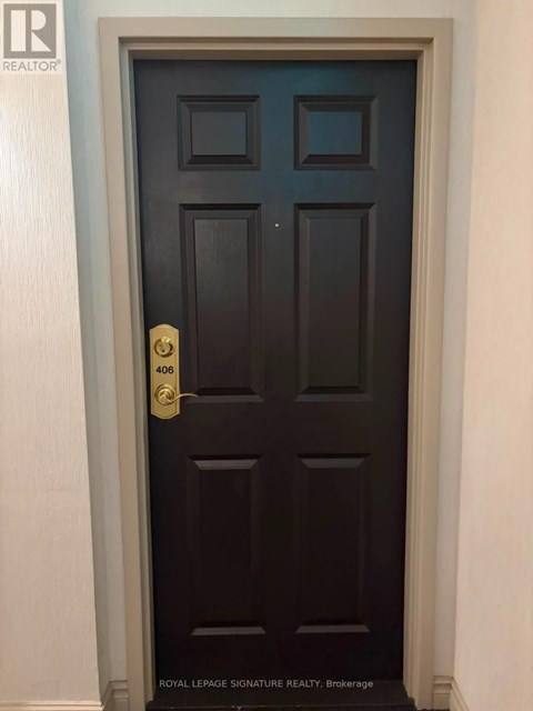 A dark brown door with a gold handle and a number 406 on it.