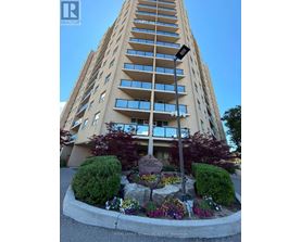 A tall building with a flower bed in front of it.