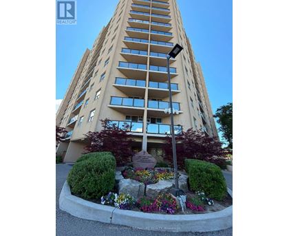 A tall building with a flower bed in front of it.