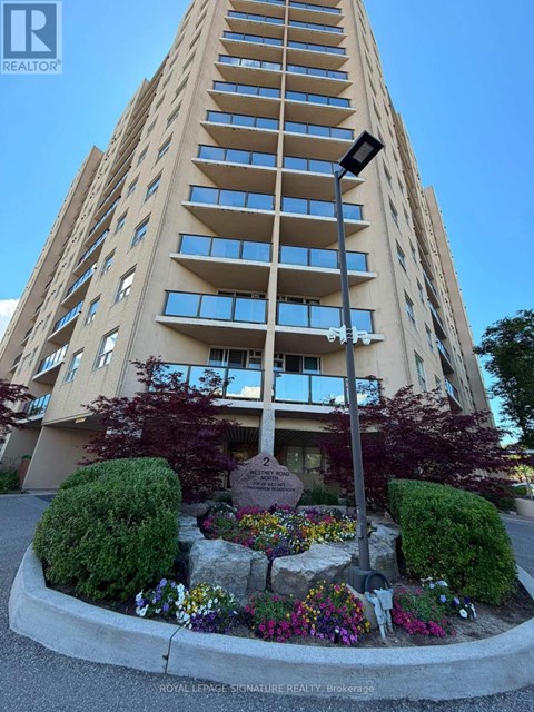 A tall building with a flower bed in front of it.