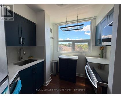 A kitchen with dark blue cabinets and a white countertop.