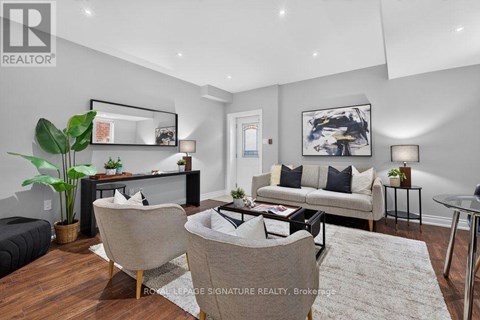A living room with a couch, chairs, and a coffee table.