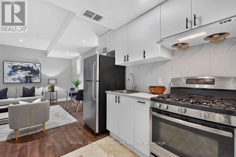 A modern kitchen with a refrigerator, stove, and oven.