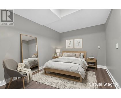 A bedroom with a large bed and a chair.