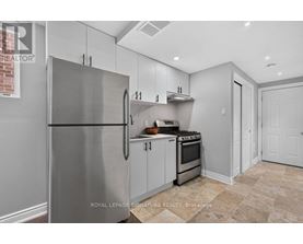 A kitchen with a stainless steel refrigerator and a tiled floor.