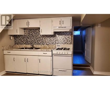 A kitchen with white cabinets and a black and white backsplash.