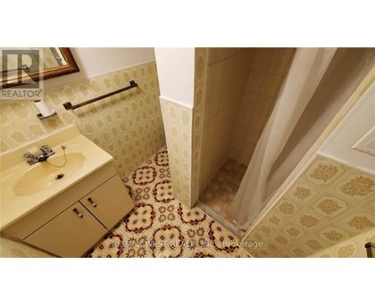 A bathroom with a tiled floor and a shower area.