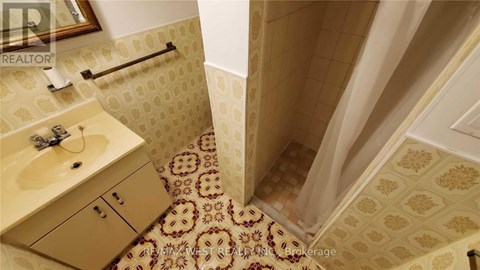 A bathroom with a tiled floor and a shower area.