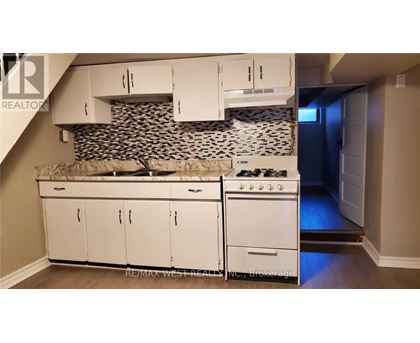 A kitchen with white cabinets and a black and white tiled backsplash.