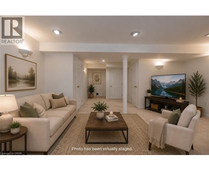 A living room with a couch, chair, and a painting on the wall.