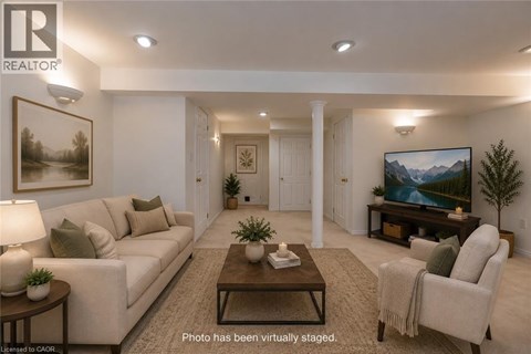 A living room with a couch, chair, and a painting on the wall.