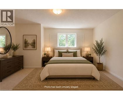 A bedroom with a large bed, a dresser, and a potted plant.