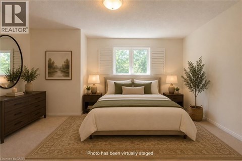 A bedroom with a large bed, a dresser, and a potted plant.