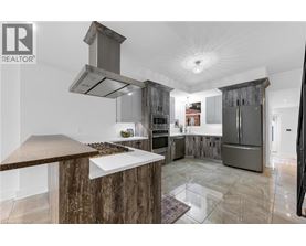 A modern kitchen with a wooden island and stainless steel appliances.