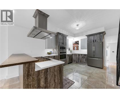 A modern kitchen with a wooden island and stainless steel appliances.