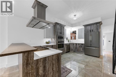 A modern kitchen with a wooden island and stainless steel appliances.