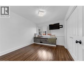 A bedroom with a bed and a wooden floor.