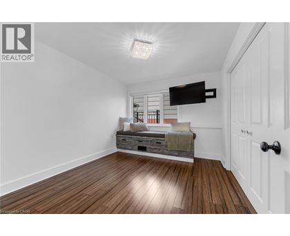A bedroom with a bed and a wooden floor.